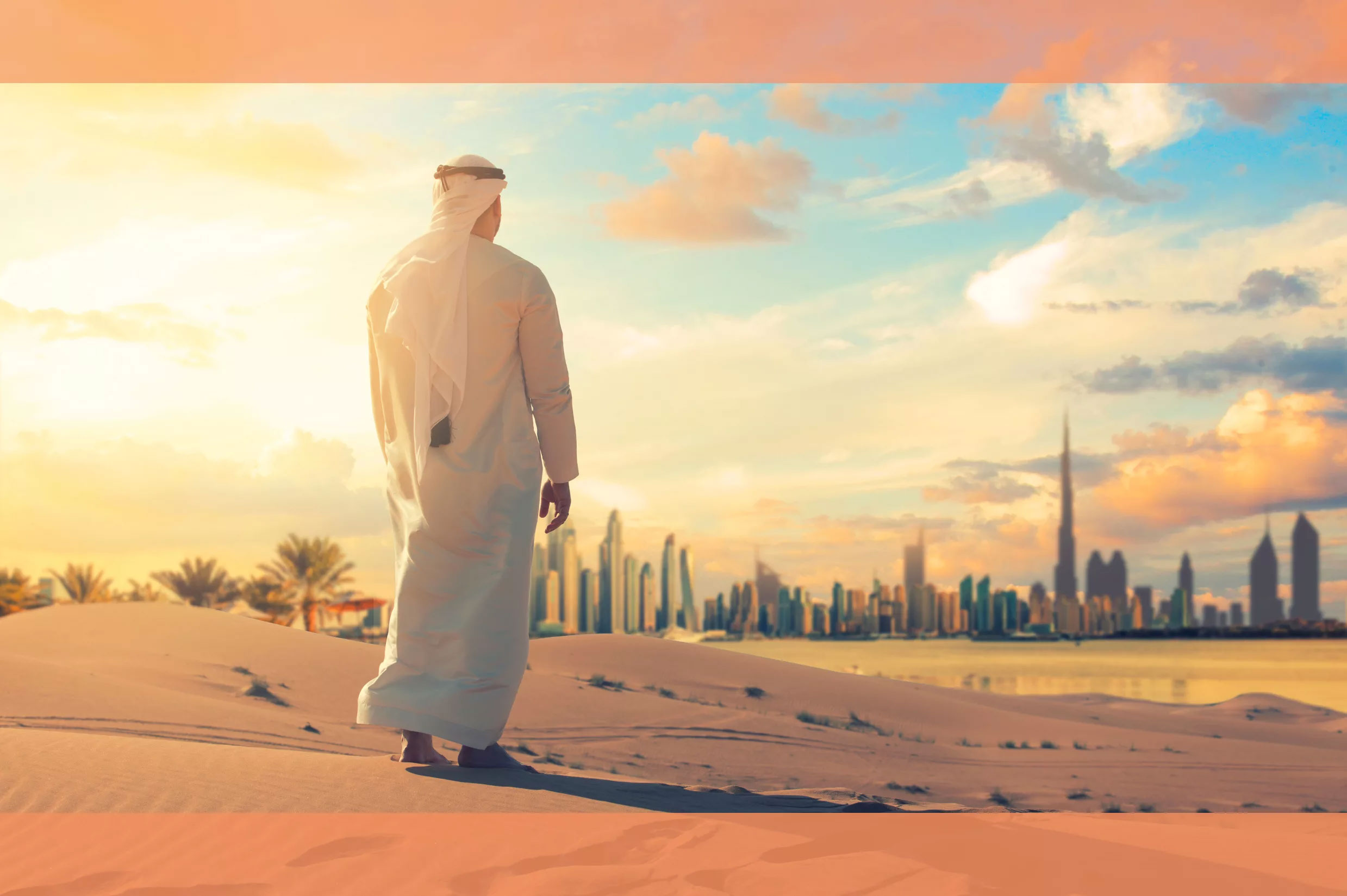 Man standing in the sand with Dubai in the background